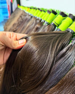 Woman wearing natural dark brown human hair extensions, silky and straight – Black Diamond Collection.